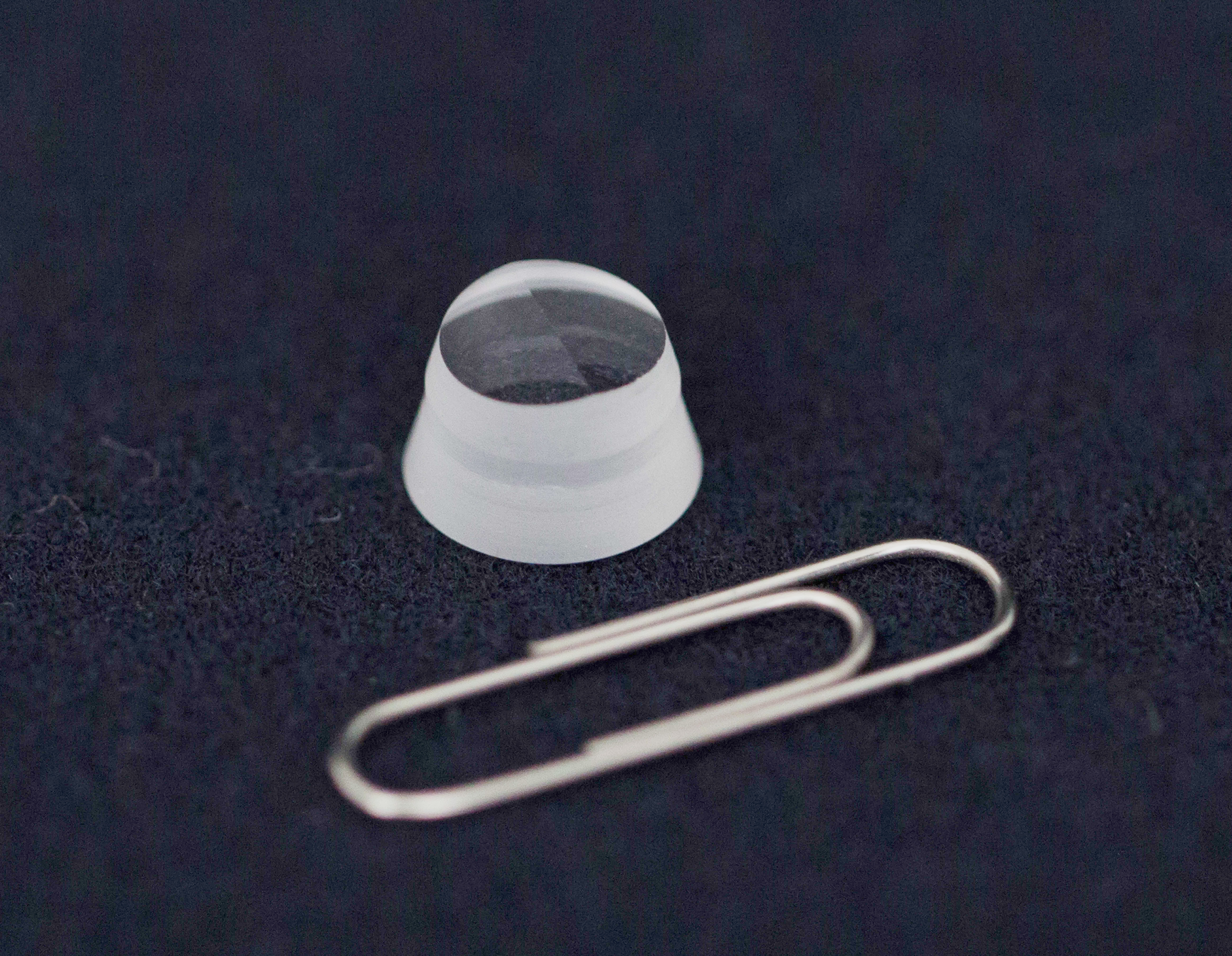 Small sapphire cone next to a paperclip for scale