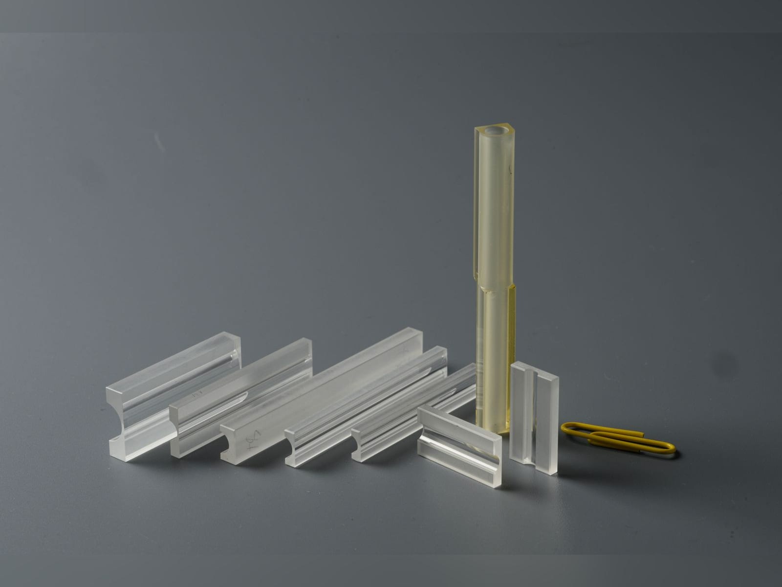 Glass flow tube profiles of different lengths next to a paper clip