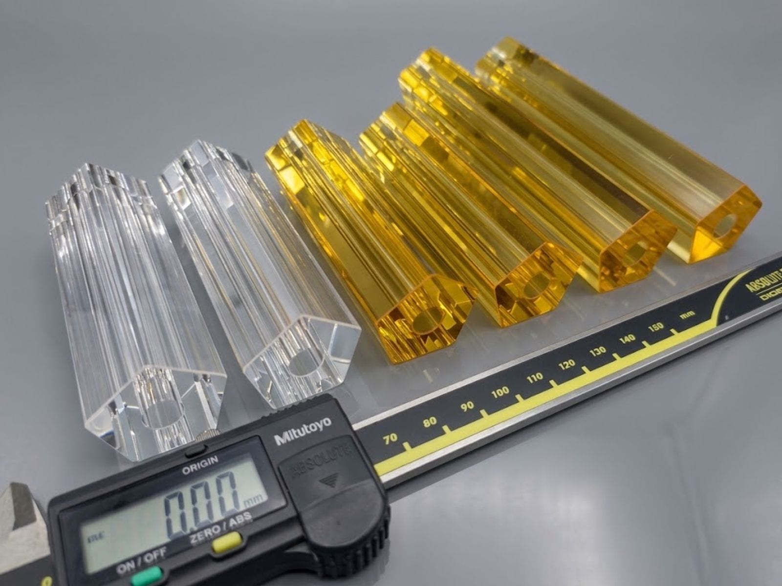 Clear and yellow pentagonal flow tubes next to a digital caliper