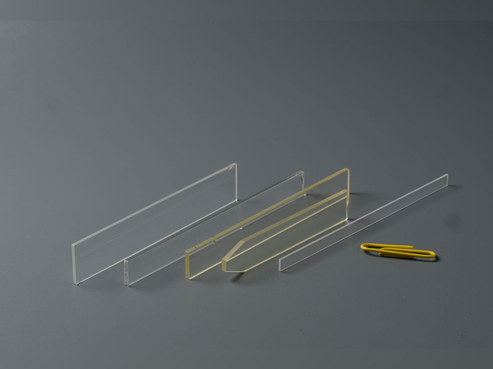 Clear and yellow flow plates next to a paper clip
