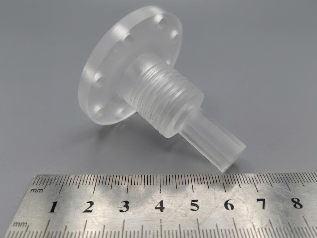 Threaded stepped window part next to a ruler